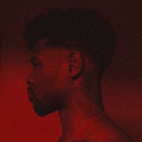 a man with tattoos in front of a red background